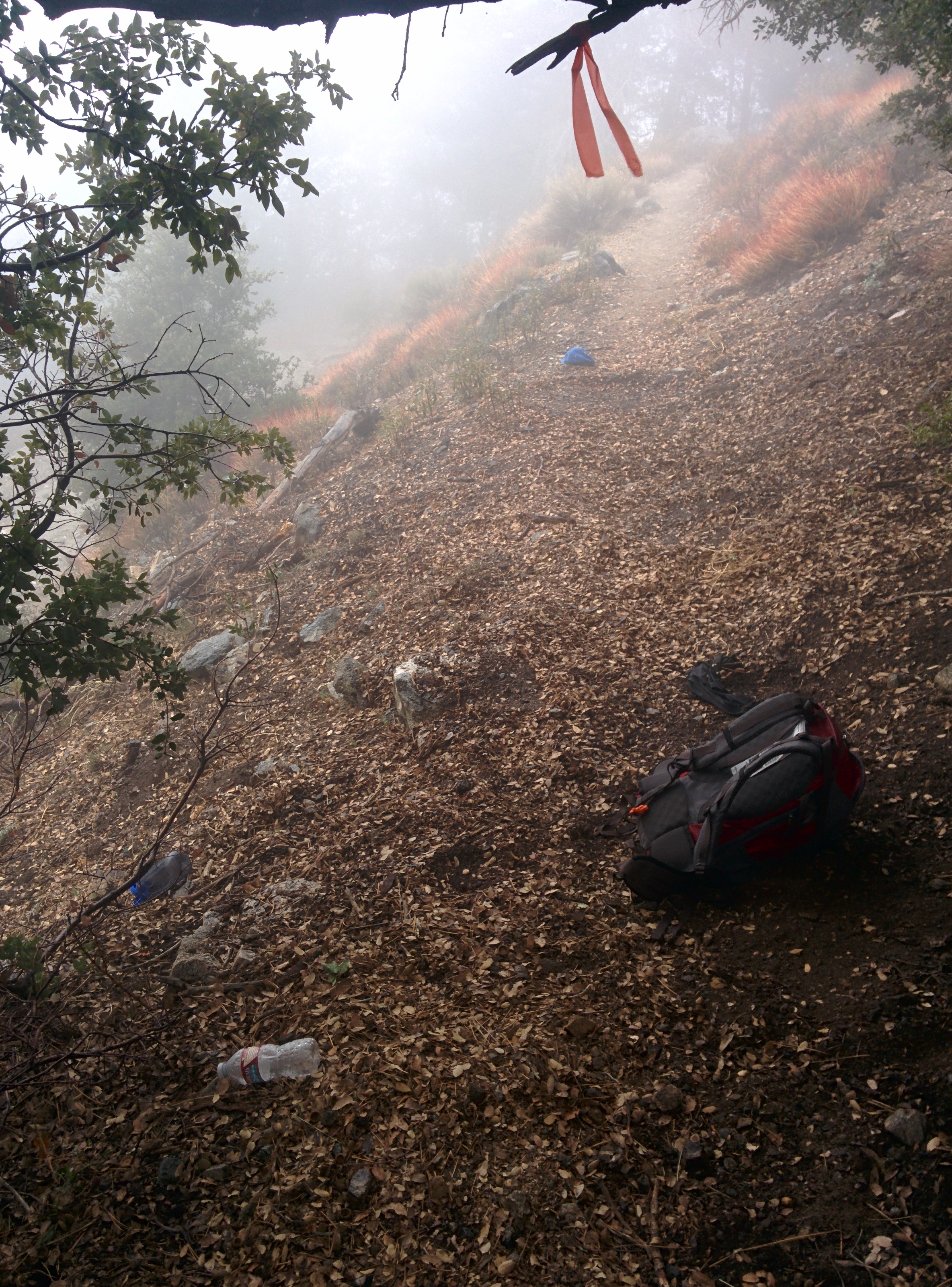 A backpack and hiking gear abandoned in the middle of the trail.